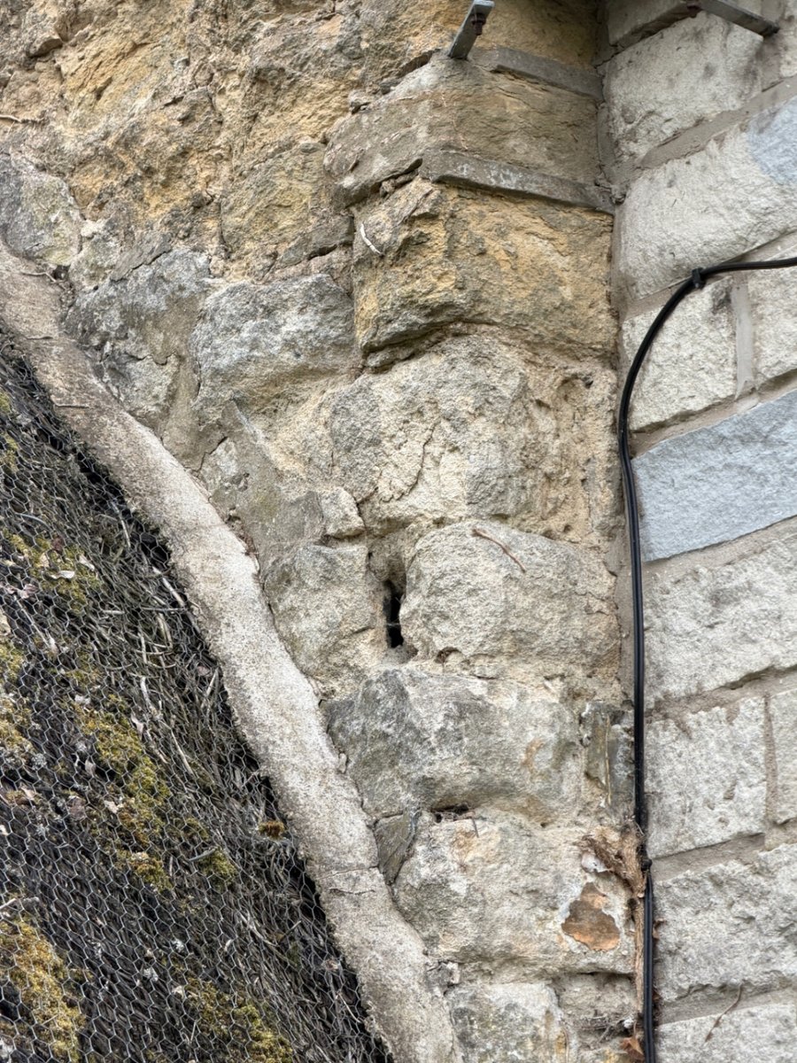 Weathered sandstone masonry at historic roof junction